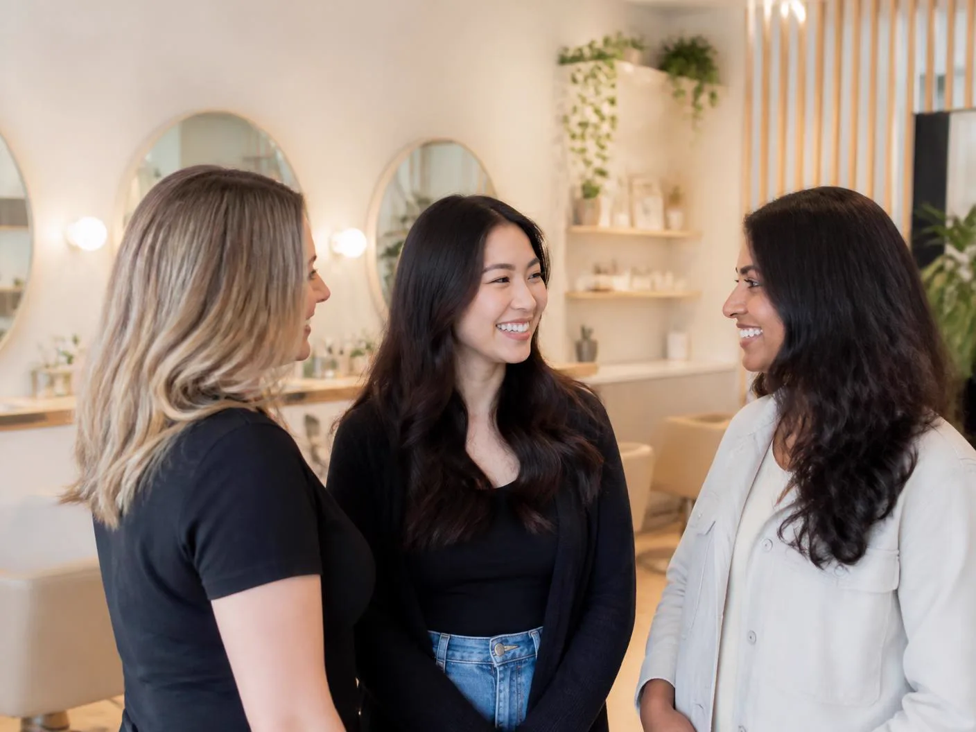 Three Canadian beauty clients talking together in a modern salon